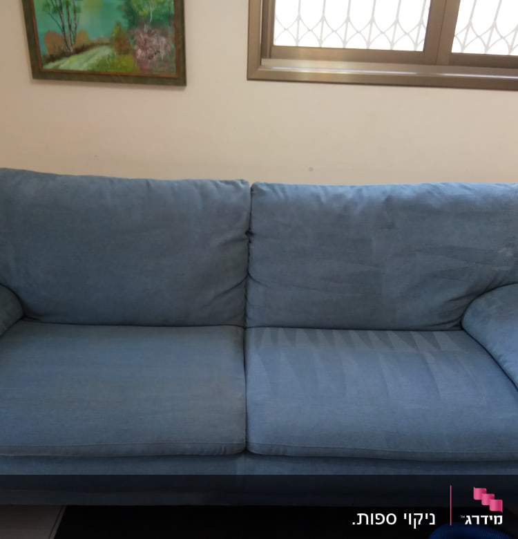 ספה כחולה עם סימני ניקוי על המושב